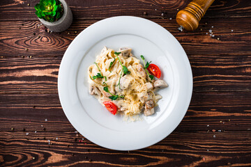 Canvas Print - Linguini pasta with chicken fillet, mushrooms, cheese, cream sauce, tomatoes and herbs.