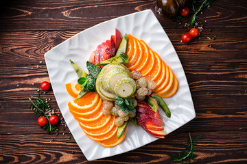 Poster - Fruit plate of oranges, pears, grapes, apples, mint, sprinkled with powdered sugar.