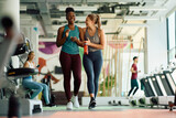Cheerful athletic women having fun during sports training in gym.