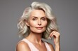 Beautiful gorgeous 50s mid aged mature woman looking at camera isolated on Gray. Mature old lady close up portrait. Healthy face skin care beauty, middle age skincare cosmetics