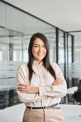 Confident smiling young professional Asian business woman corporate leader, happy japanese female employee, company sales marketing manager, standing arms crossed in office, vertical portrait.