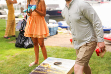 People Playing Cornhole, A Popular American Sport, Representing Camaraderie, Outdoor Leisure, Competition, And The Spirit Of Friendly Gatherings