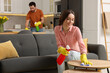 © New Africa - Spring cleaning. Lovely couple tidying up living room and kitchen together