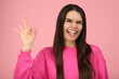 © New Africa - Happy young woman showing her tongue and making ok gesture on pink background