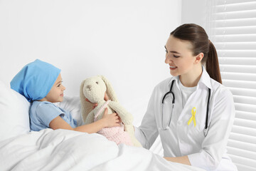 Canvas Print - Childhood cancer. Doctor and little patient with toy bunny in hospital