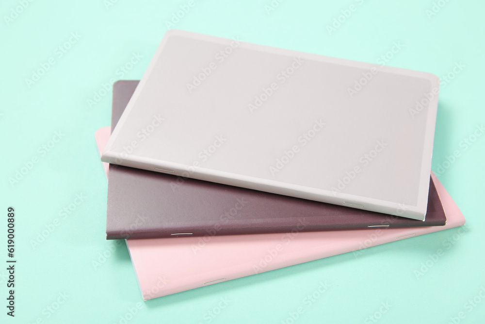 Different colorful notebooks on turquoise background