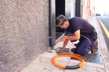 Working Woman.female Engineer Of A Telecommunication Company Doing The Installation Of Fiber Optics In A House.telephone Company Worker Installing Fiber Optics In A House.