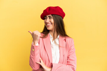 Wall Mural - Young caucasian woman isolated on yellow background pointing to the side to present a product