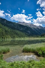  Landscape view of the clear water surrounded by high mountains. Jagersee river in Kleinarl. Austria