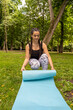 Bienestar al aire libre: Chica activa creando su propio oasis de calma, colocando su esterilla de yoga en el suave césped para disfrutar de una práctica rejuvenecedora al aire libre