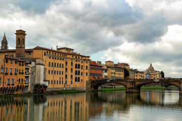 Wall Mural - A picturesque view of Ponte Vecchio, the oldest bridge in Florence, with the River Arno flowing beneath it