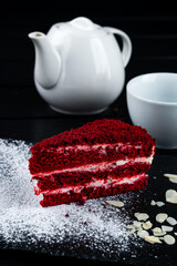 Poster - Piece of red velvet cake with almonds and powdered sugar with teapot and cup, fresh dessert with drink.