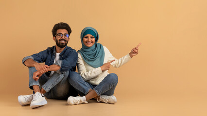 Poster - Check This. Young Arabic Spouses Pointing Aside At Copy Space