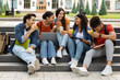 Group Of Happy Multiethnic Students Relaxing Outdoors In Campus