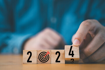 Wall Mural - businessman flipping of 2023 to 2024 on wooden block cube for preparation new year change and start 