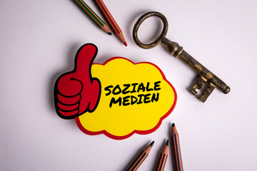 Wall Mural - social media text in german on a sticky note. white office desk