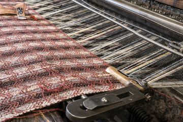 weaving of tartan on a historic loom machine