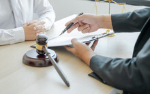 Lawyer Hand Holding Pen And Providing Legal Consult Business Dispute Service At The Office With Justice Scale And Gavel Hammer