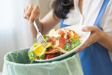 Compost From Leftover Food Asian Young Housekeeper Woman, Female Hand Holding Salad Bowl Use Fork Scraping Waste, Rotten Vegetable Throwing Away Into Garbage, Trash Or Bin. Environmentally Responsible