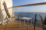 Fototapeta Morze - Cruise ship balcony with two chairs and table.