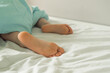 © Irina Satserdova - Children's legs stick out from under the blanket. A child's bed with protruding legs. Cute baby heels