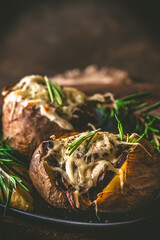 Wall Mural - Baked potatoes with mushrooms, sour cream and cheese on a rustic wooden background