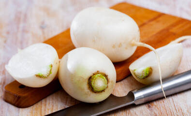 Wall Mural - Whole and cut in half ripe turnips root crops on wooden background. Healthy nutrition concept