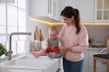 Wall Mural - Mother and her cute little baby spending time together in kitchen