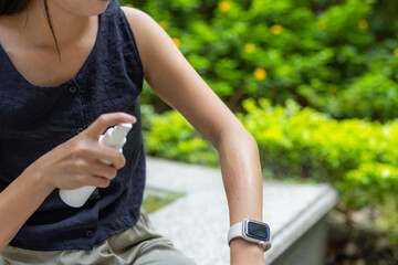 Woman apply mosquito repellent on hand