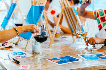 sip and paint event: women creating art over wine glasses