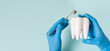 Health dental care concept. Dentist holds white healthy tooth model in his hands on a blue background. Teeth whitening, dental oral hygiene, teeth restoration, implant concept, dentist day. Copy space