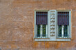 Old shabby plaster facade with a window renaissance ornament and metal bars