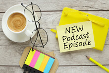 new podcast episode text on yellow sticky note on yellow notepad near coffee cup