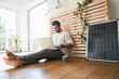 © Westend61 - Smiling businessman sitting by solar panel and using laptop at home