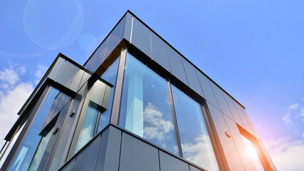 graphite facade and large windows on a fragment of an office building against a blue sky. modern alu