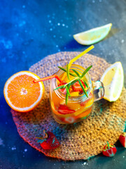Wall Mural - refreshing summer lemonade with strawberry, orange and lemon. top view