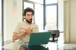 young adult bearded man with a laptop looking puzzled and confused, insecure and pointing in opposite directions with doubts