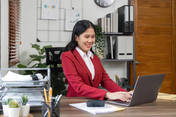 Sticker - Portrait of beautiful smiling young businesswoman sitting at bright in office modern work and typing on laptop