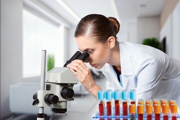 Poster - Professional scientist working in modern laboratory, looking in a microscope