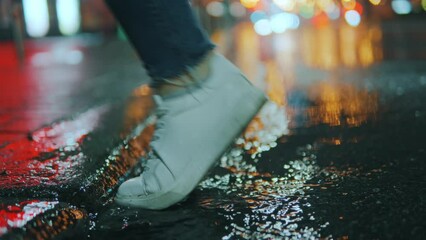Wall Mural - the foot of an unrecognizable person steps into a puddle, breezes fly