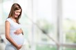 © BillionPhotos.com - Portrait of young happy pregnant woman holding her belly