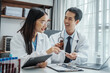 © M+Isolation+Photo - Asian medical doctors specialist in white lab coats working together, discussing at meeting about blood test results, anemia, infection in the bloodstream, diabetes