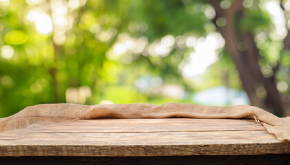 table wood for coffee product, Empty wooden table and sack tablecloth over blur park, garden outdoor with bokeh light background