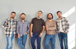 © Studio Romantic - Portrait of a male bearded friends looking cheerful at the camera and smiling on grey wall background. Full length photo of a group of brutal friendly men laughing in casual clothes.