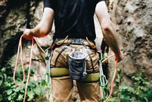 Male Rock Climber With Climbing Equipment Holding Rope Ready To Start Climbing The Route