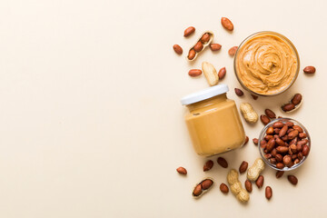 Wall Mural - Bowl of peanut butter and peanuts on table background. top view with copy space. Creamy peanut pasta in small bowl