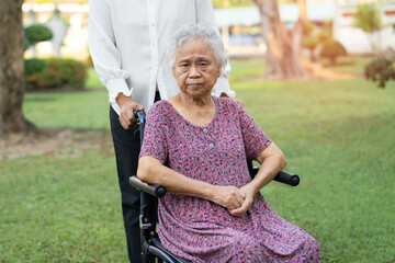 Wall Mural - Caregiver help and care Asian elderly woman use walker with strong health while walking at park in happy fresh holiday.