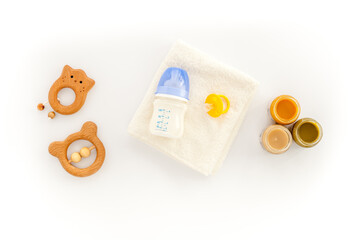 Feeding baby bottle with milk and kids accessories on table, top view. Childcare concept