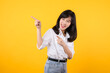 © Jirawatfoto - Businesswoman. young asian woman happy smile dressed in white shirt showing pointing finger hand gesture to free space isolated on a yellow background. presenting advertising advice promotion concept.