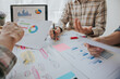© NanTua - teamwork Business people analyzing investment graphs, brainstorming meeting and discussing plans in conference room, investment concept.